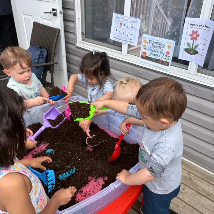 Niños explorando tierra y naturaleza en el jardín sensorial