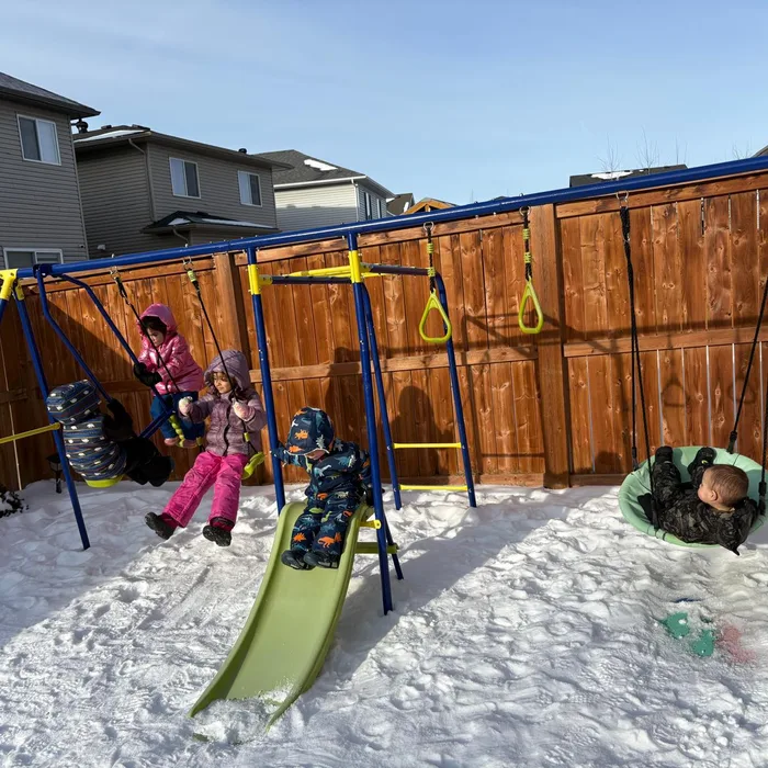 Niños jugando en los columpios durante el invierno