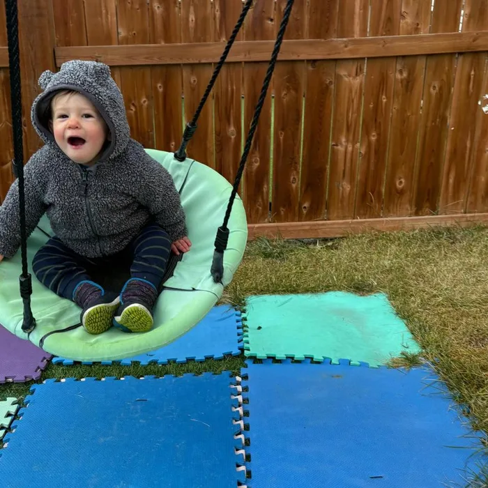 Niño columpiándose al aire libre