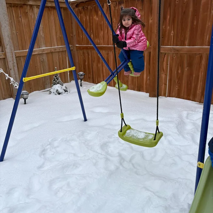 Niña columpiándose en la nieve