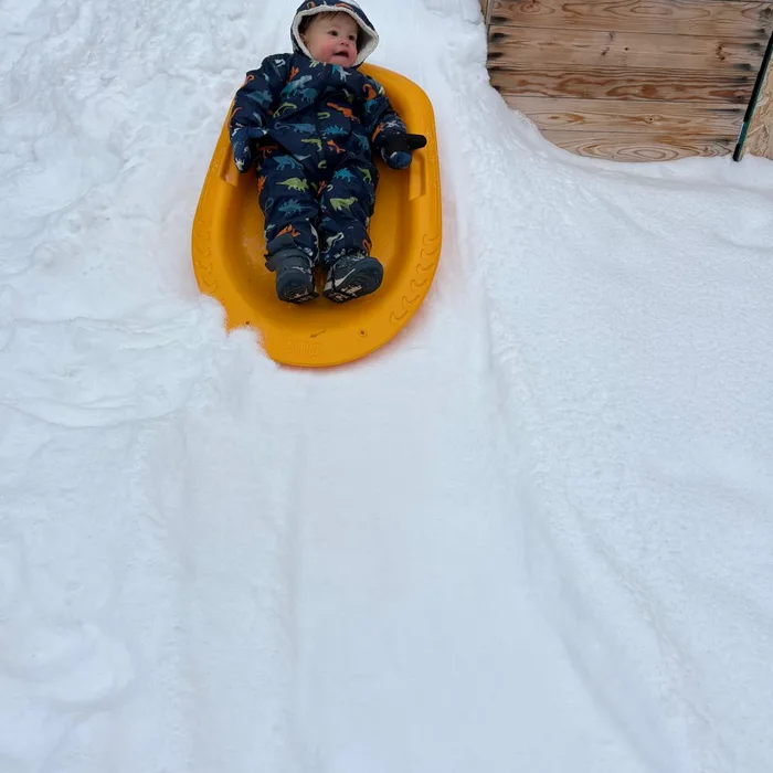 Bebé deslizándose en trineo sobre la nieve