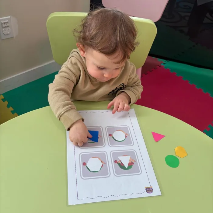 Niño realizando actividad de emparejar figuras