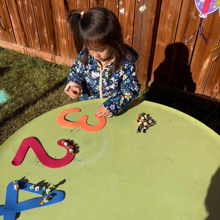 Niña jugando al aire libre con figuras