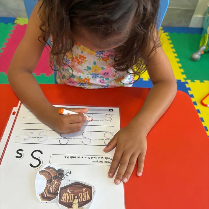 Niña practicando escritura de letras