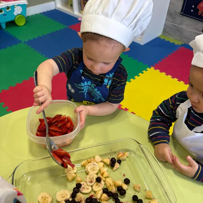 Niños con gorros de chef disfrutando de un snack