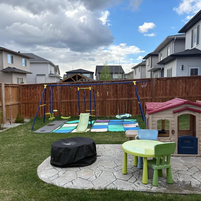 Patio trasero con juegos y área de picnic